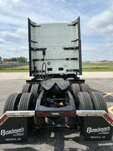 Truck tractor rear view showing fifth wheel and dual rear axles with mud flaps and Bruckner's Wichita KS branding.