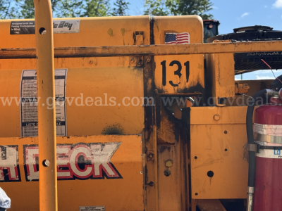Yellow Mack equipment showing number 131, decals, and safety labels on side panel.