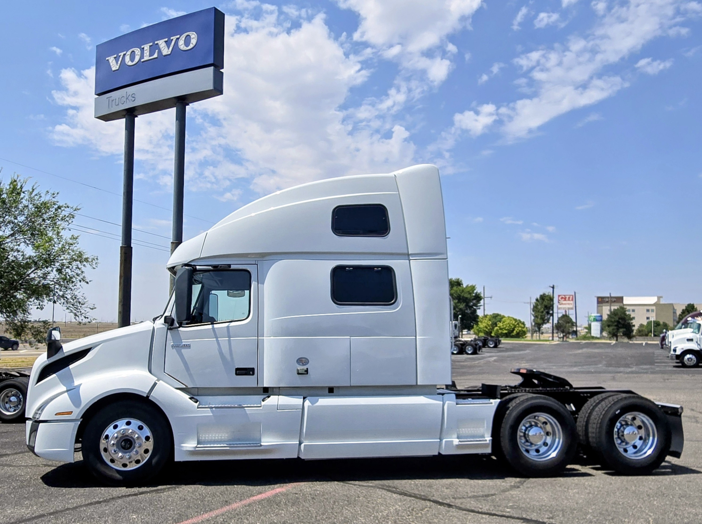 Volvo VNL64T860 tractor with sleeper cab, side view showing chrome rims and aerodynamic design.