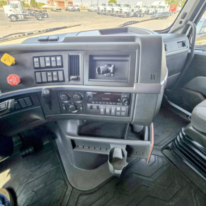 Volvo VNL64T860 truck cab dashboard with control panel, steering wheel not visible, gear selector and cup holder area visible.