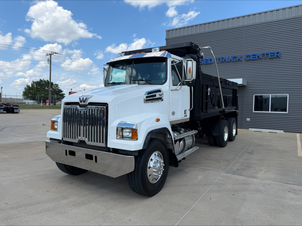 White 2018 Western Star 4700SF dump truck parked outside a dealership, with chrome grille and dump bed visible.