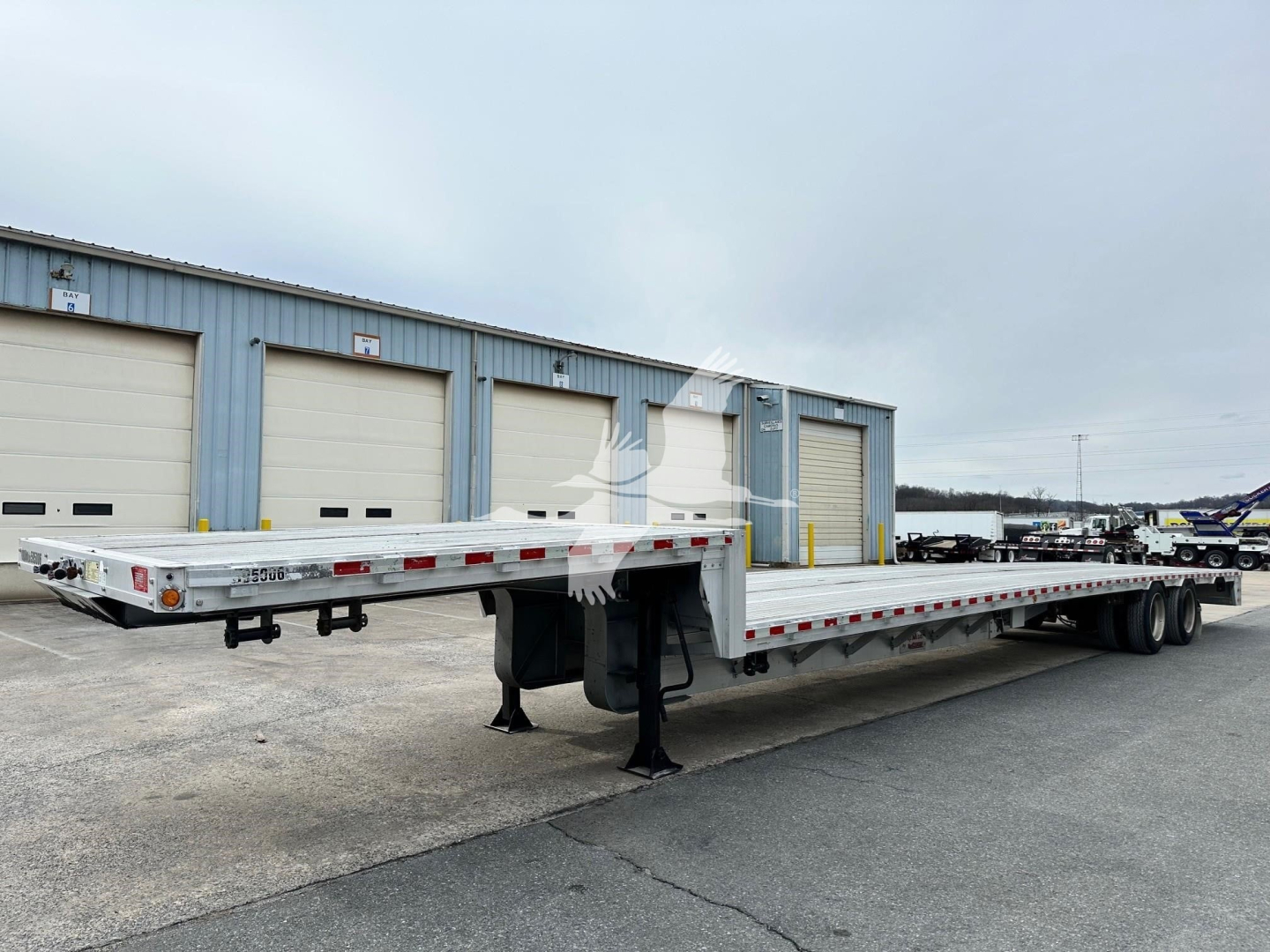 2019 Reitnouer Dropmiser trailer with flatbed and drop deck, side rails, tandem axles, and landing legs. VIN 1RND53A20KR049408 visible with stock number 7732.