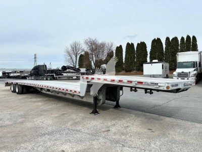 Drop deck trailer showing long flatbed with 'Dropmiser' feature and rear loading area, white with reflective tape, truck cab in distance.