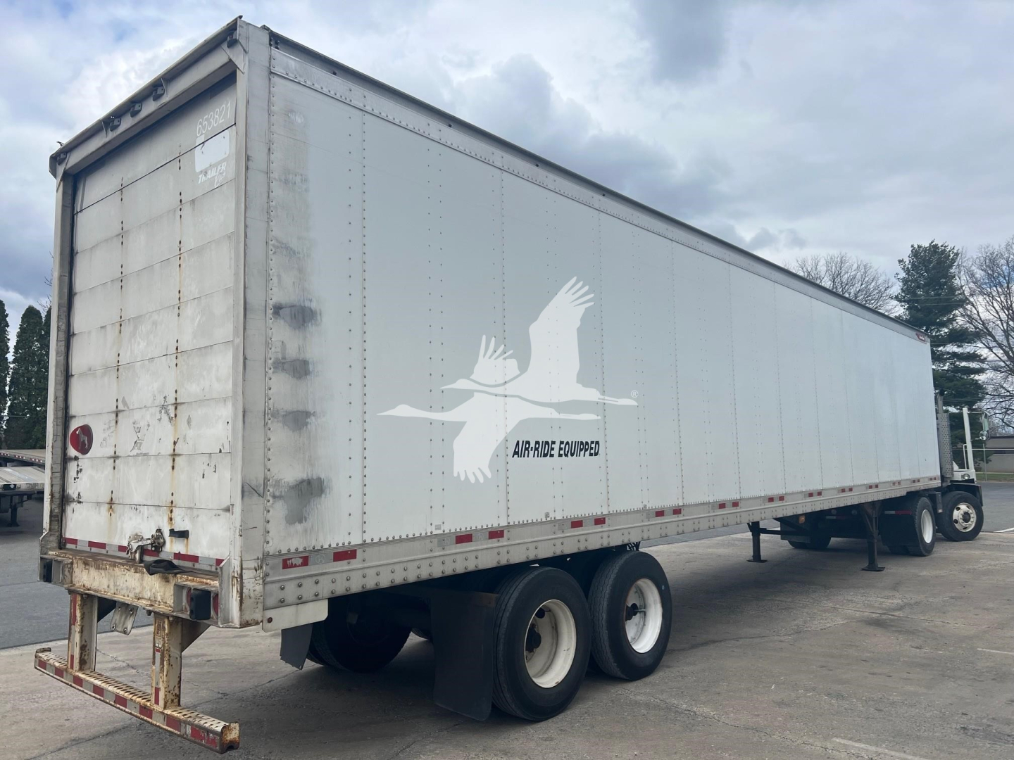 Great Dane trailer side view showing sheet and post roll door with air-ride logo and rear twin axle configuration.
