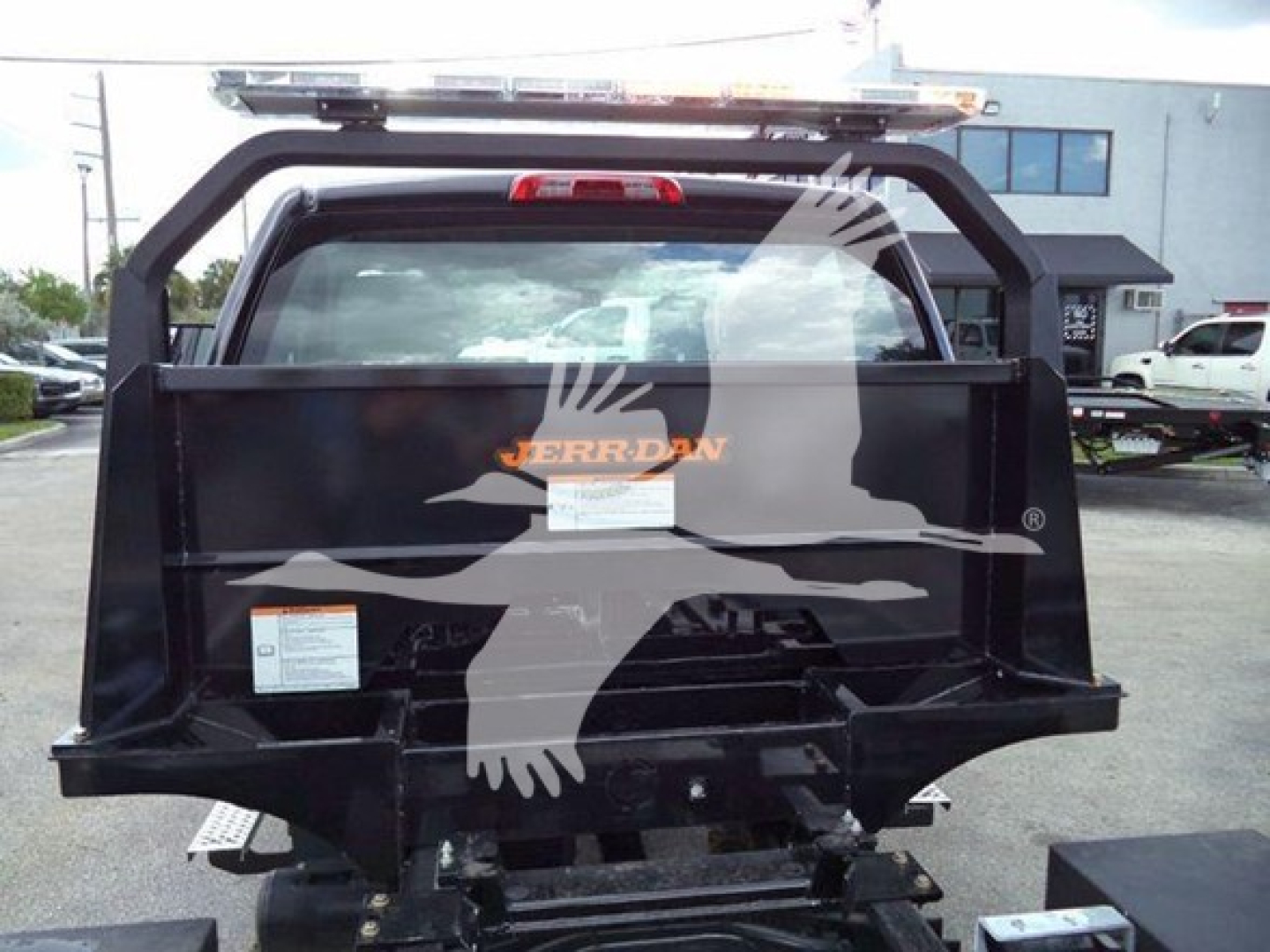 Truck bed of a 2023 Chevrolet Silverado 6500Hd rollback showing Jerr-Dan branding and rear view with lift equipment.