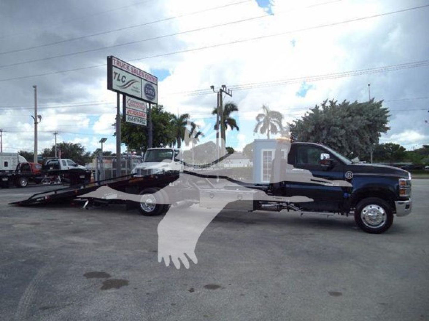 Chevrolet Silverado 6500HD rollback tow truck with flatbed in a dealership lot, VIN 1HTKHPVM0PH556216, stock J56216.