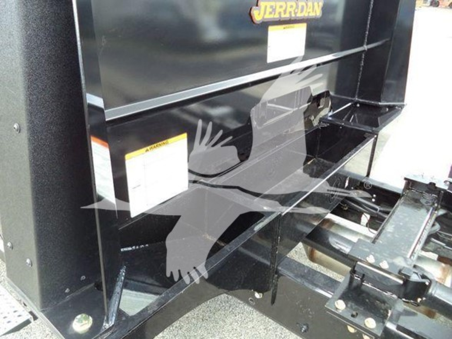 Truck bed area of a new 2023 Chevrolet Silverado 6500HD rollback unit showing metal frame, hitch assembly, and hydraulic components with JERR-DAN branding.