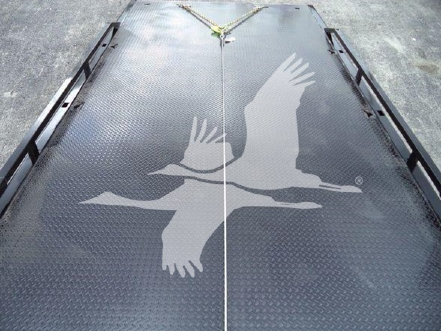 Tray showing a raised diamond-plate steel surface with a white two-flying-geese logo in the center.