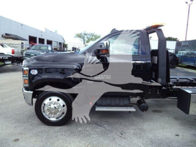 Truck cab side view showing Chevrolet Silverado 6500HD chassis with single rear wheel and equipment for rollback service.