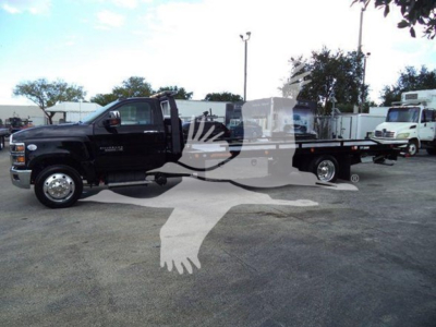 Chevrolet Silverado 6500HD tow truck body side view with rollback bed and extended cab showing black finish.
