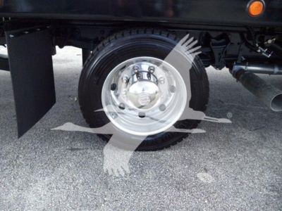 Truck wheel and dual rear axle area showing steel wheel, lug nuts, and part of suspension underframe.