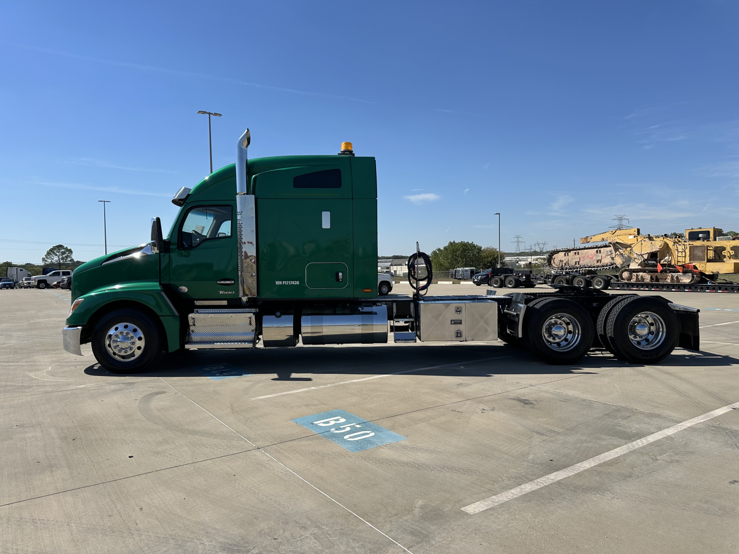 Kenworth T680 conventional sleeper truck side view showing green cab and silver chassis