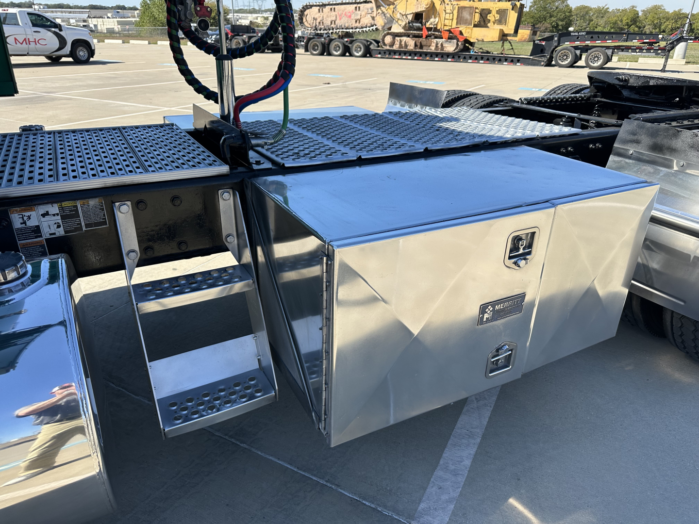 Kenworth T680 bed side storage box mounted on trailer chassis with polished aluminum toolbox and steps.
