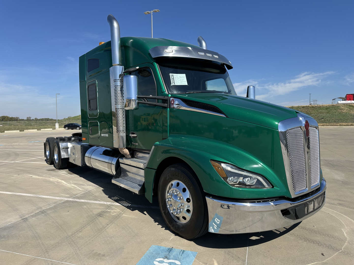 Kenworth T680 conventional sleeper truck in green, front-left view showing chrome grille, dual exhaust stacks, large chrome bumper, and polished wheels.