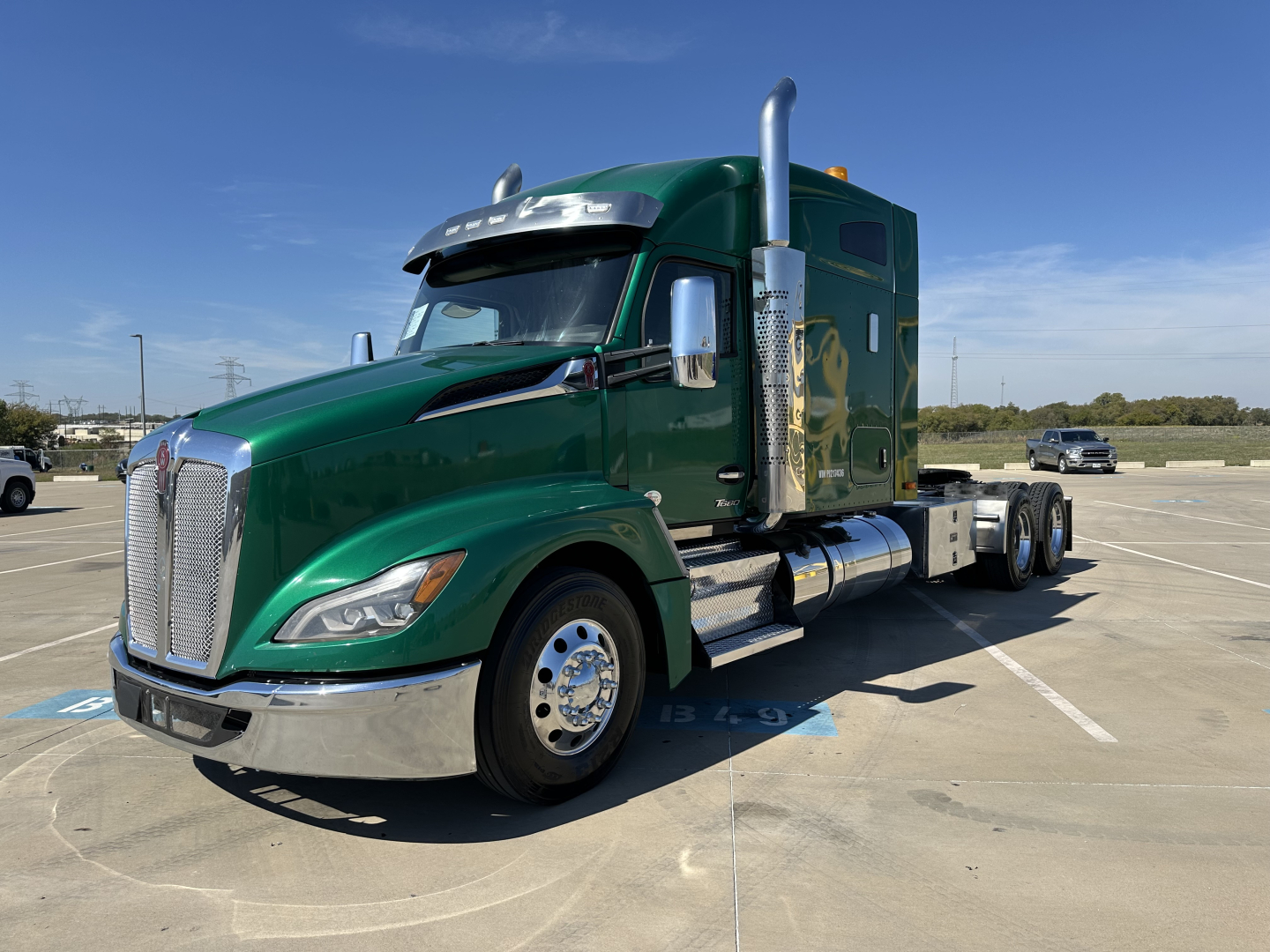 Kenworth T680 conventional sleeper truck in green with chrome stack exhaust and dual rear axles, front grille, and side mirrors visible.