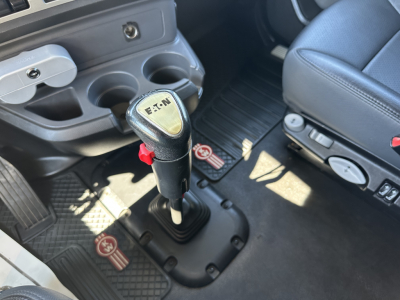 Kenworth T680 interior showing manual shifter with Eaton branding and center console with cup holders.