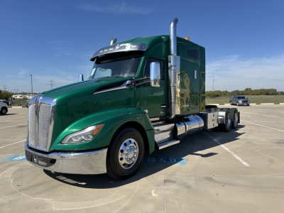 Kenworth T680 conventional sleeper truck in green with chrome stack exhaust and dual rear axles, front grille, and side mirrors visible.