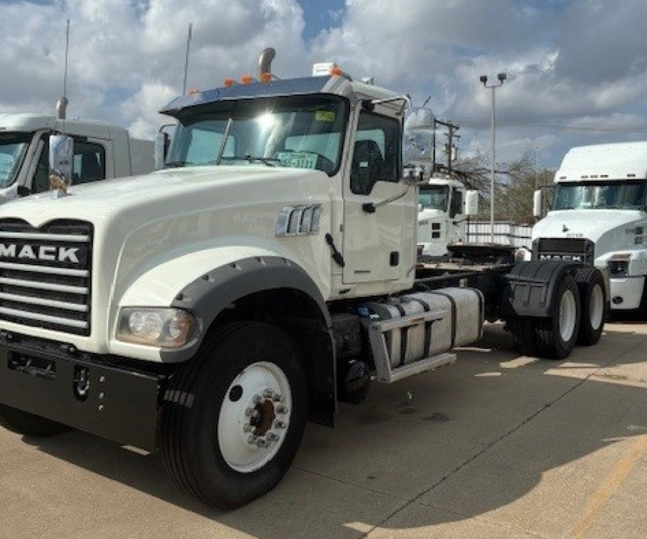 Mack GR64FT conventional daycab tractor showing front-left view with white cab and black grille.