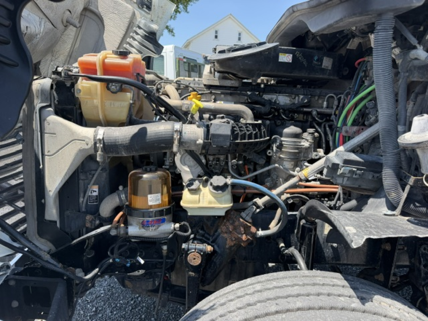 Engine bay of a 2017 Freightliner Cascadia CA125DC with visible components like coolant reservoir, hoses, and engine parts.