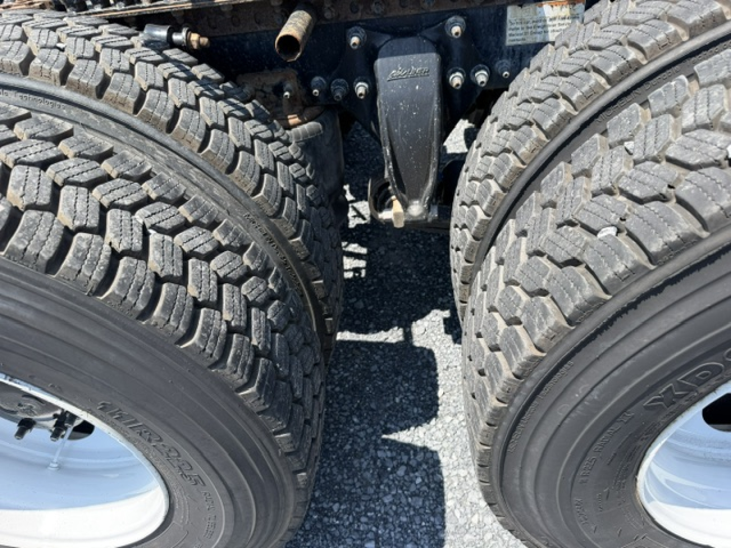 Freightliner Cascadia CA125DC truck drivetrain area showing tandem rear axles with dual tires and suspension components.
