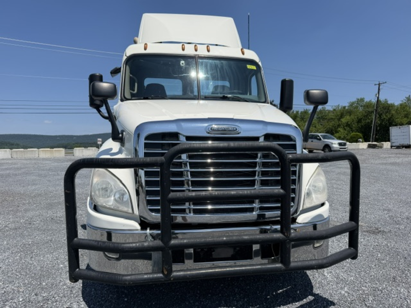 Front view of a 2017 Freightliner Cascadia CA125DC conventional daycab truck with a heavy grille guard and dual mirrors.