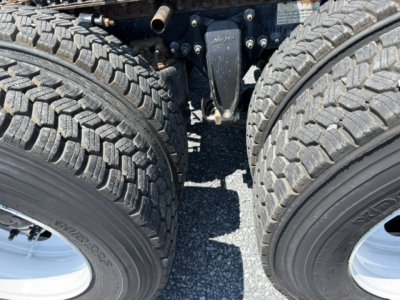 Freightliner Cascadia CA125DC truck drivetrain area showing tandem rear axles with dual tires and suspension components.