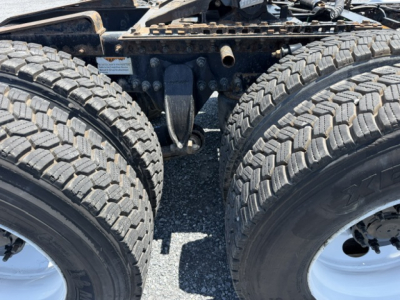 Freightliner Cascadia truck rear dual tires and chassis showing dual rear axles and suspension components.