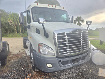 Freightliner Cascadia daycab front view showing large chrome grille, headlights, and bumper.