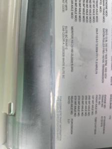Truck info label on a Freightliner Cascadia showing engine, transmission, and axle data with technical specs and codes.