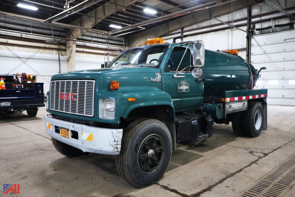 GMC Topkick SL Series 1000 Gallon Jetter Truck in a warehouse showing front grille and side tank with orange beacon lights.