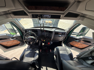 Kenworth W990 cab interior with steering wheel, dashboard, and two front seats visible