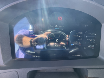Kenworth W990 instrument cluster display showing speedometer at 0 mph, digital gauges, and VIN/stock in reflection.