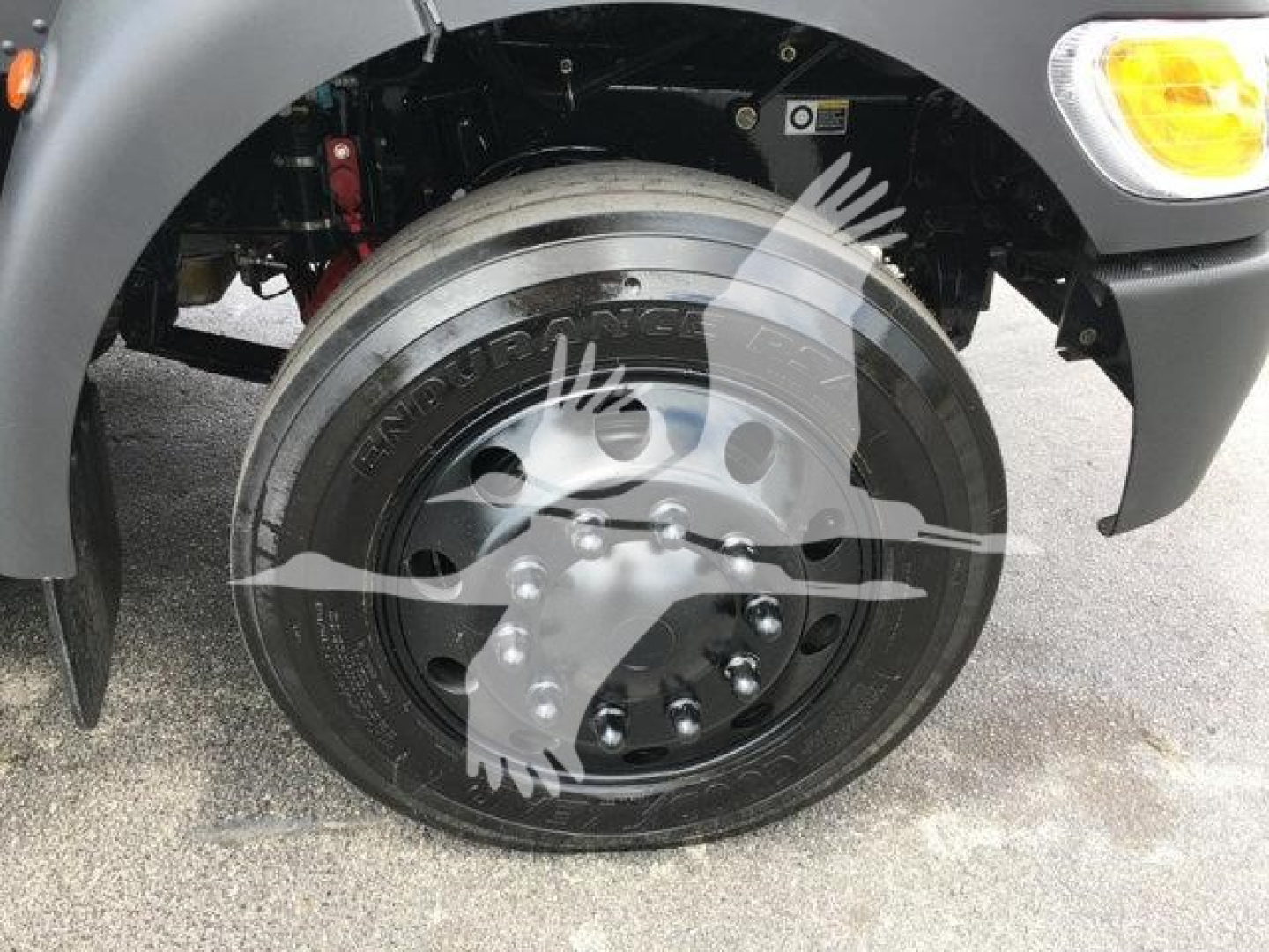 Front wheel of a 2022 Peterbilt 337 rollback truck showing a large Michelin-style light truck tire mounted on a steel wheel with hub and fender.