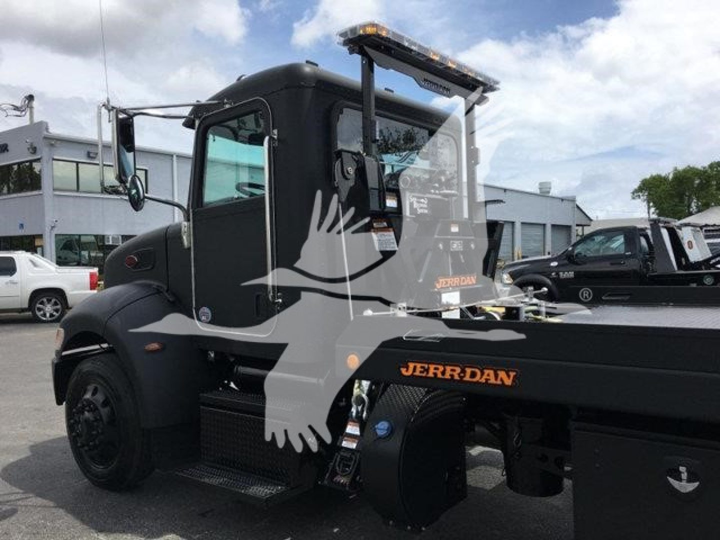 Peterbilt 337 rollback truck side view showing black cab and Jerr-Dan wreckers/flatbed equipment with visible Jerr-Dan branding.
