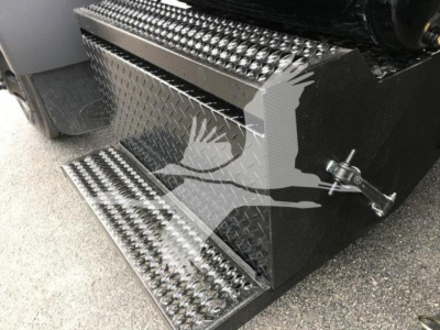 Step-type metal entry stairs on a 2022 Peterbilt 337 rollback truck with diamond plate surface and side latch.