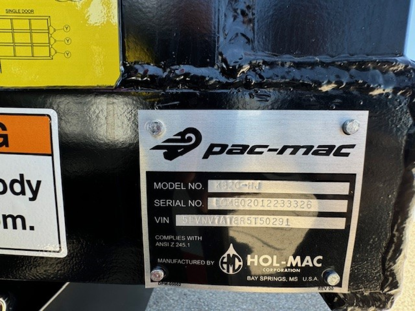 PAC-MAC plate on Hino L7 grapple truck showing model/serial/VIN fields and Hol-Mac logo.