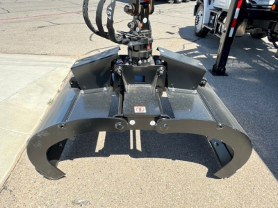 Grapple truck attachment mounted on a 2024 Hino L7 with hydraulic grapple arms visible in the foreground.