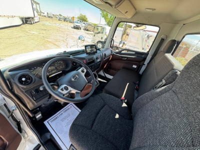 Mercedes-Benz truck interior showing steering wheel, dashboard, and front bench seat with a display screen on the dash.