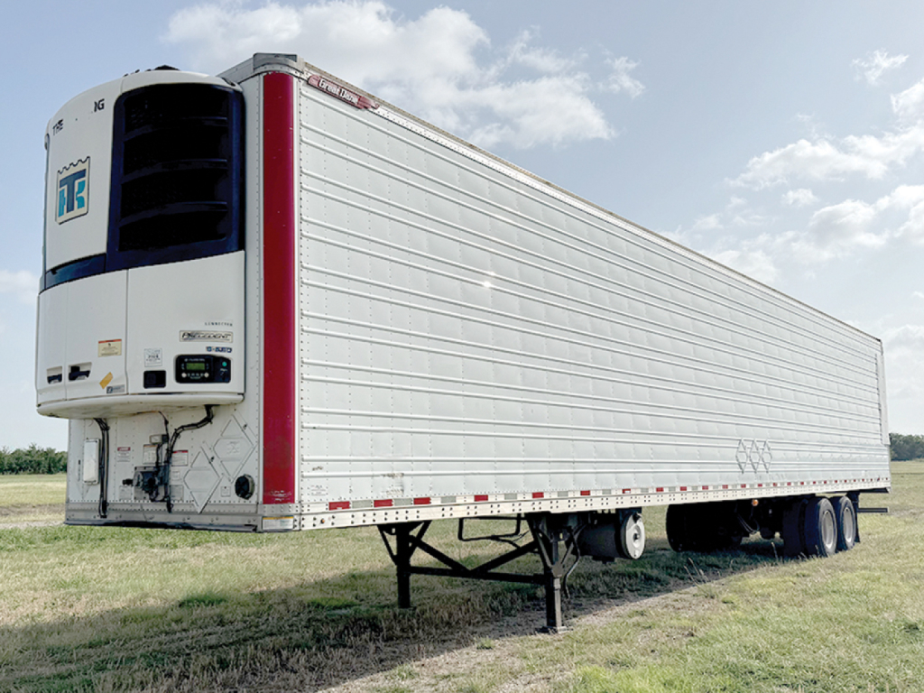 Great Dane Everest SS trailer with reefer unit at front left showing refrigeration unit and docking hitch, side view in grassy lot.