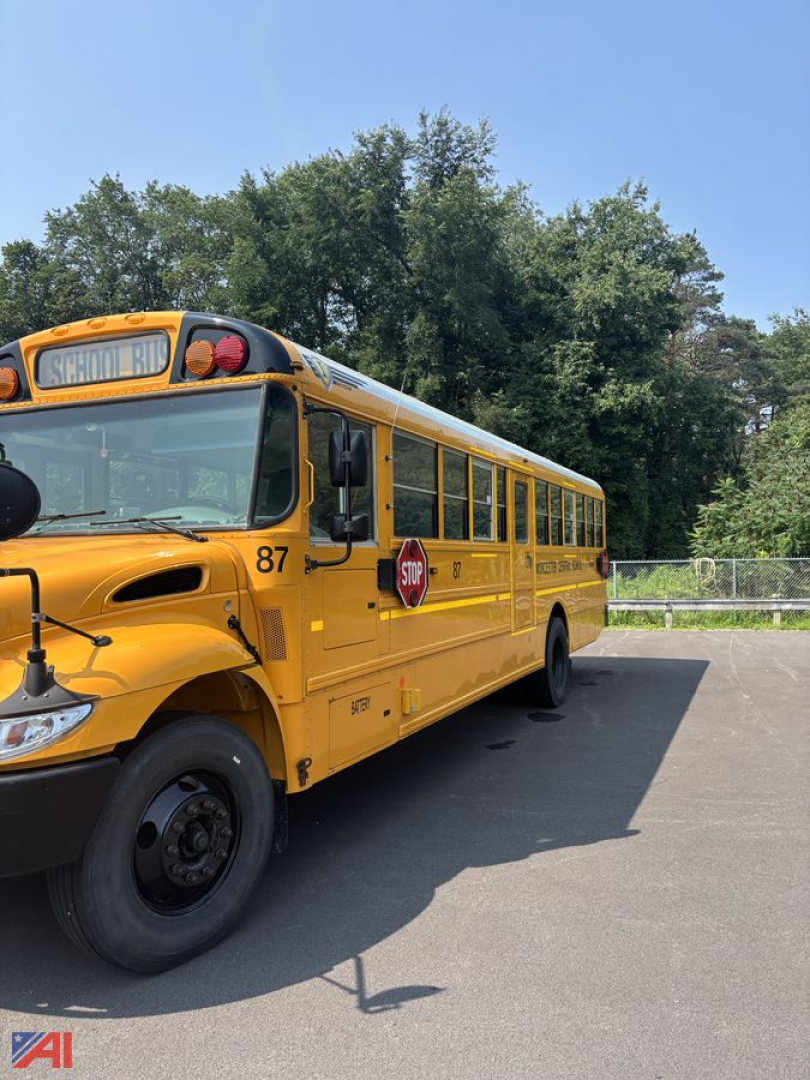 School bus side/front view showing yellow IC Corporation CE Series bus with stop sign extended, number 87, in a parking lot.