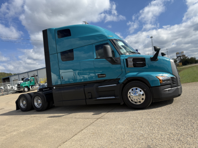 Tractor-trailer truck side view showing turquoise Mack PR64T76H with sleeper cab and dual rear axles.
