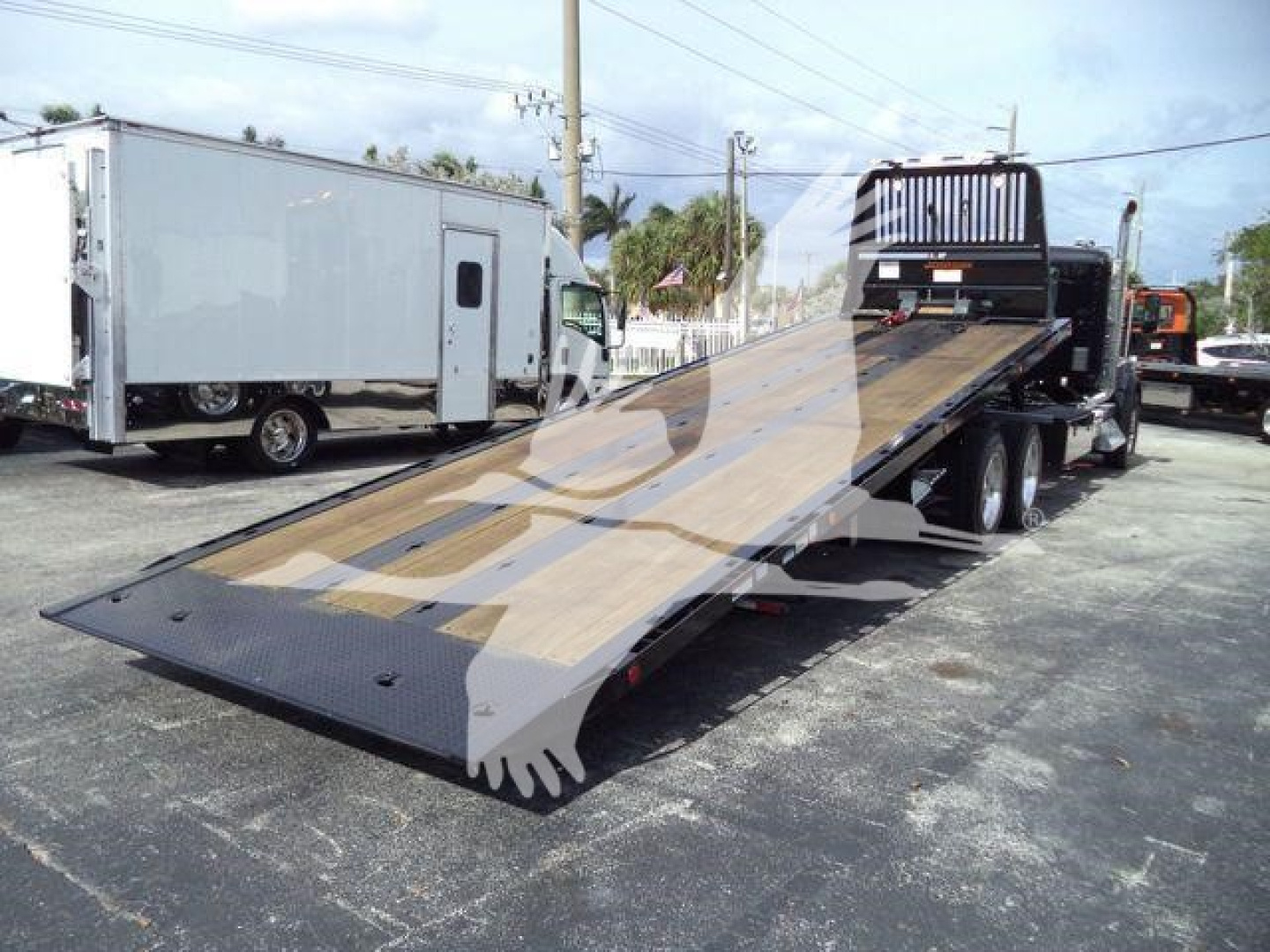 Kenworth T880 rollback tow truck with extended flatbed in serviceable condition showing loading ramp and cab view.