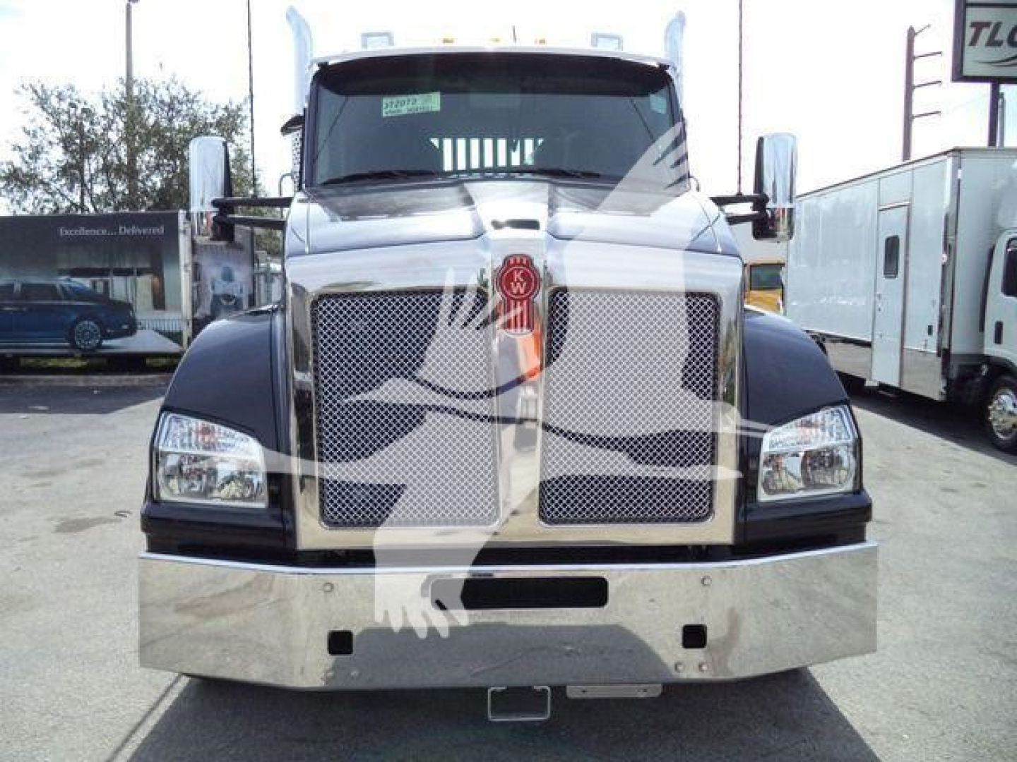 Kenworth T880 front view showing chrome grille with badge and large bumper, daytime running lights, and side mirrors.