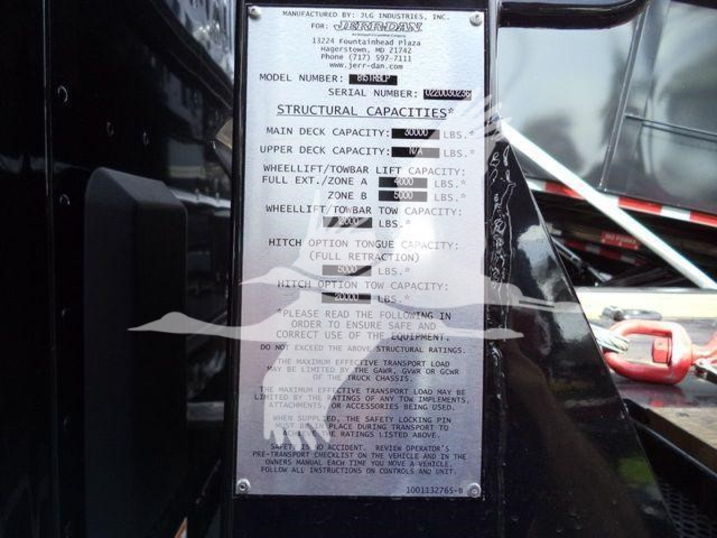 Kenworth T880 rollback truck showing structural capacities plate with text and numbers displayed.