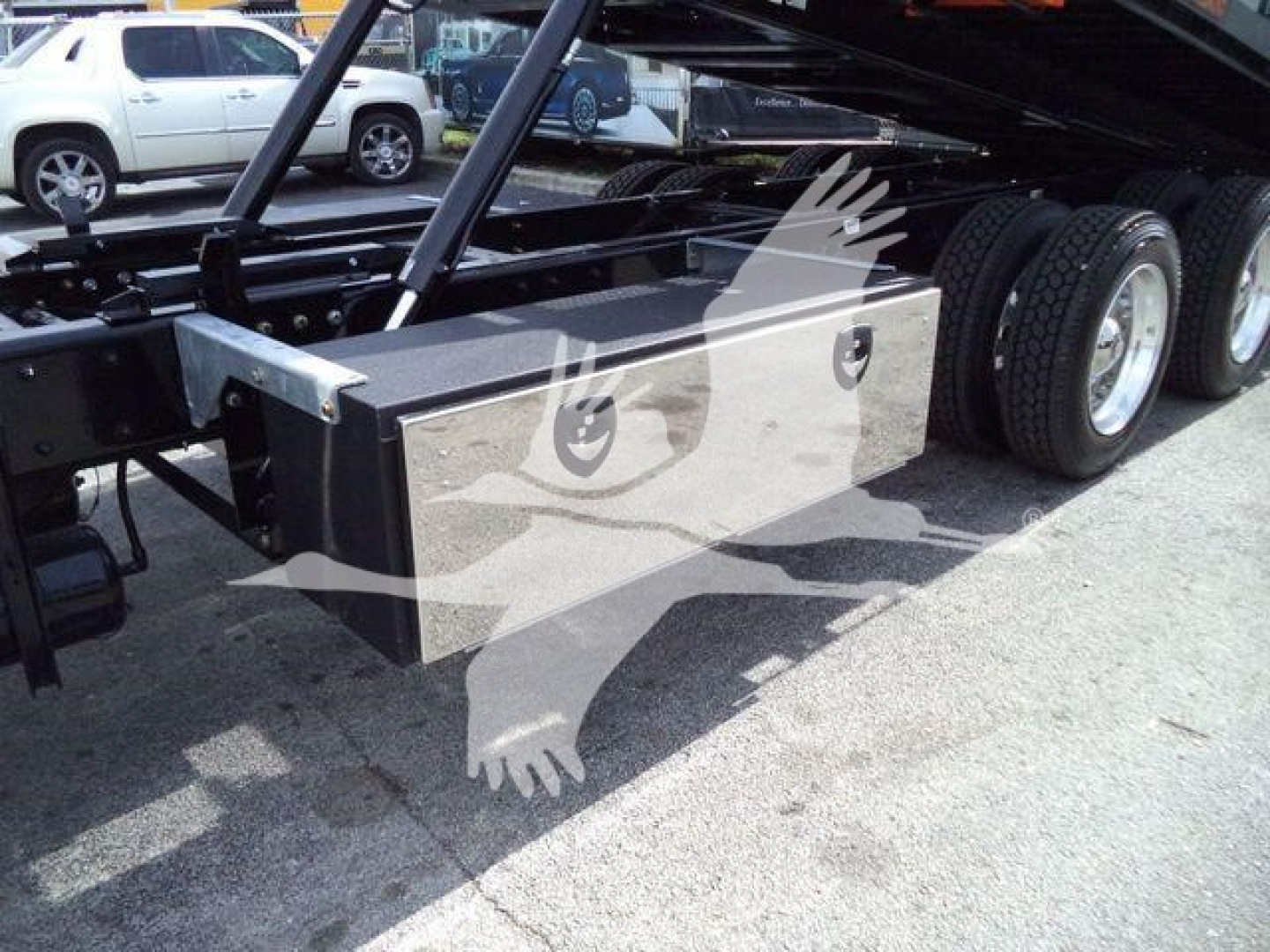 Kenworth T880 rollback truck chassis showing toolbox and dual rear wheels with hydraulic lifting mechanism.
