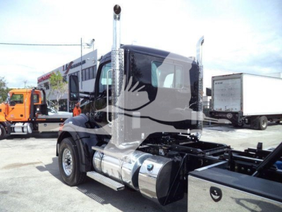 Kenworth T880 cab with chrome fuel tanks and exhaust stacks, side view showing wheel, fuel tanks, and chassis without trailer.
