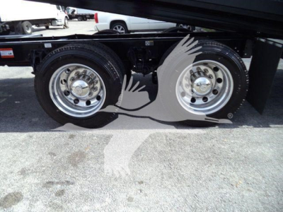 Kenworth T880 wheel area with dual rear axles on a rollback truck trailer. Visible chrome wheels and tires.