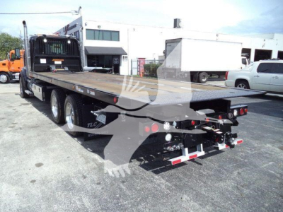 Kenworth T880 rollback truck flatbed with dual rear axles and towing equipment visible in the bed area.