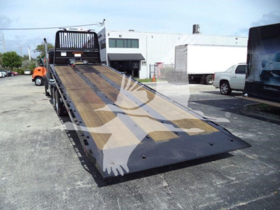 Kenworth T880 rollback truck with flatbed ramp showing loading deck and wheel straps. Visible text includes stock number KWT880HD15T and vehicle category details in listing context.