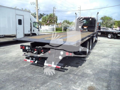 Kenworth T880 rollback chassis rear view showing flatbed and hydraulic hookup ports.